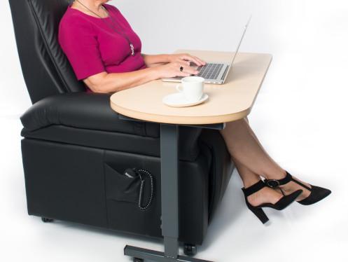 Vrouw die in een relax zetel zit met een laptop e ts koffie op een bijzettafeltje